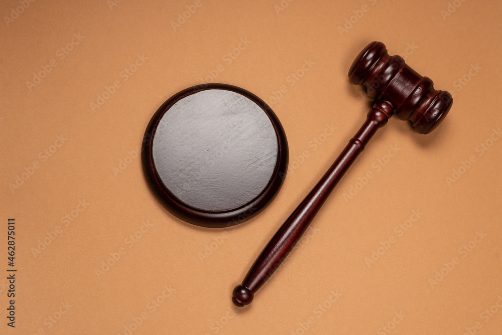 Gavel down on stand on brown background. Justice of law system conceptual. Gavel down on stand on brown background. Justice of law system conceptual.