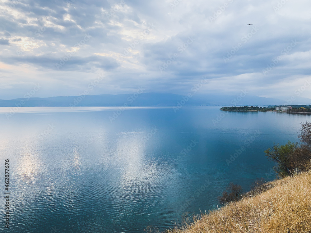 White cloudy sky reflection on the surface of the blue lake White cloudy sky reflection on the surface of the blue lake