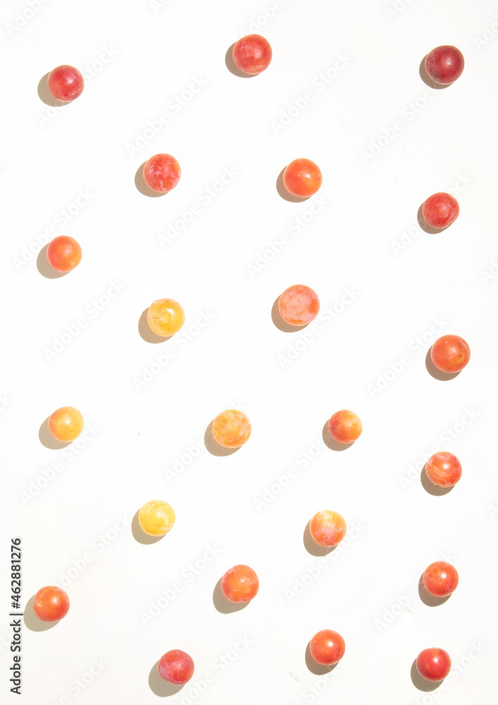 Minimal layout with wild plums on pastel beige background. Colorful fruit concept. Summer color harmony flat lay idea. Minimal layout with wild plums on pastel beige background. Colorful fruit concept. Summer color harmony flat lay idea.