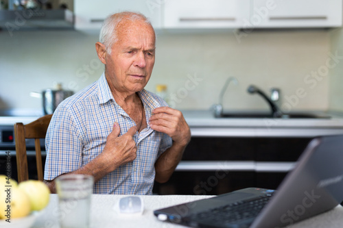 Modern elderly man sit at home having online consultation with doctor on computer, sick senior male talk on video call consulting using laptop. Healthcare concept