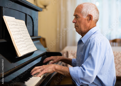Old man playing piano at home