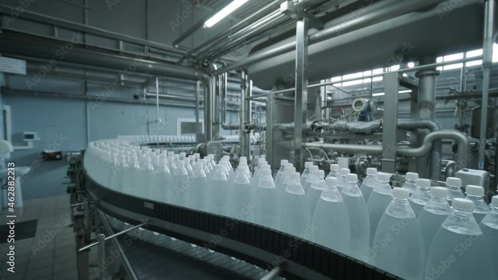 Conveyor belt with bottles of drinking water at a modern beverage plant Conveyor belt with bottles of drinking water at a modern beverage plant