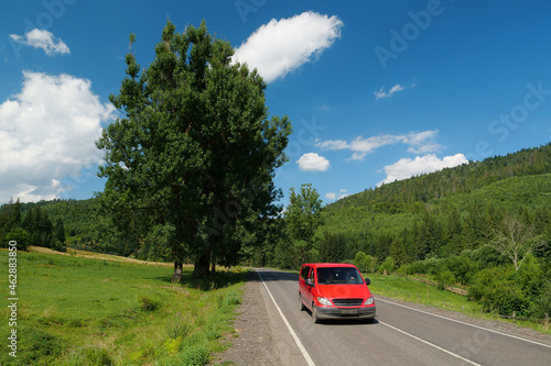 Red car driving on scenic road photo