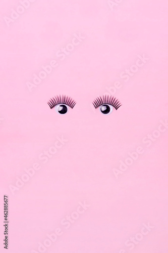 Creative makeup concept with  pink glasses, eyelashes and heart on the pink background. Makeup creative concept. Flat lay.