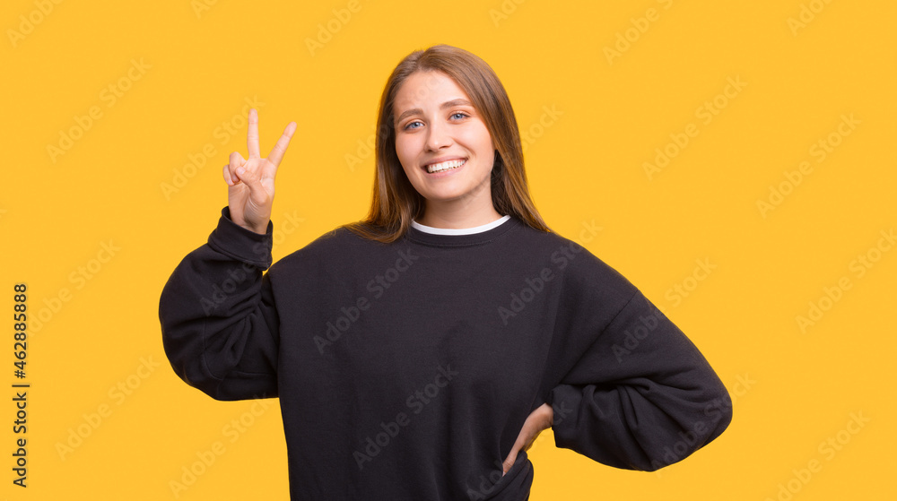 Smiling at the camera blonde lady is showing the v sign. Smiling at the camera blonde lady is showing the v sign.