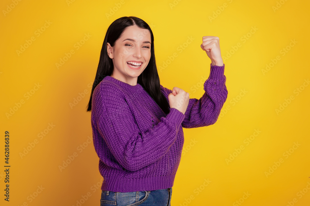 Portrait of young excited girl raised hands fists up celebrate win victory success isolated over yellov color background Portrait of young excited girl raised hands fists up celebrate win victory success isolated over yellov color background