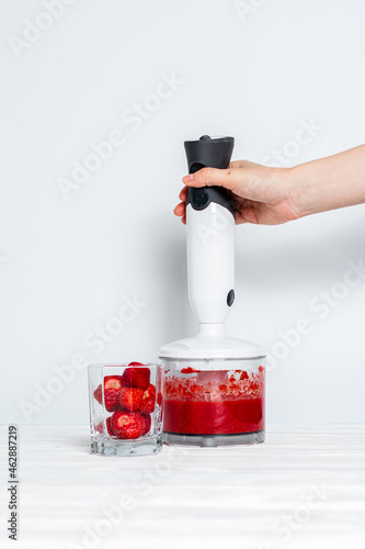 Strawberry smoothie made by hand blender