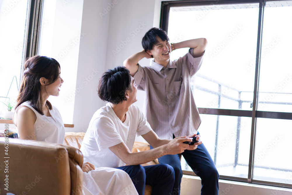 家でテレビゲームをする若い男女 家でテレビゲームをする若い男女