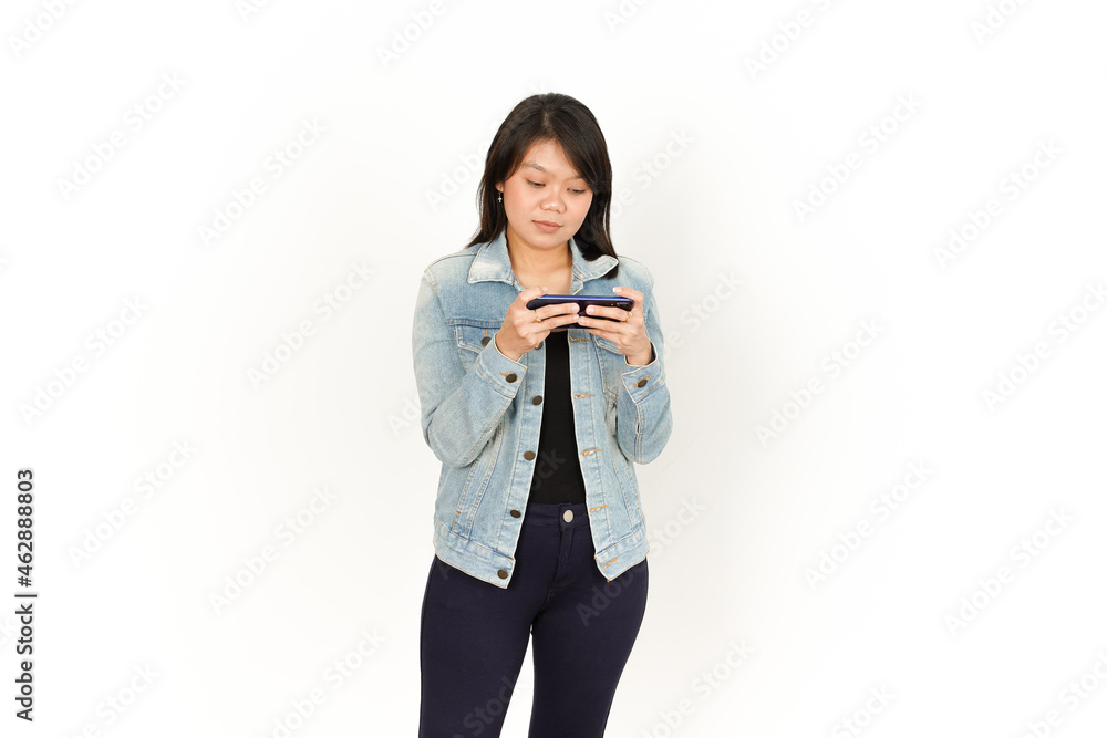 Playing Game on Phone With Happy Face of Beautiful Asian Woman Wearing Jeans Jacket and black shirt Isolated On White Background Playing Game on Phone With Happy Face of Beautiful Asian Woman Wearing Jeans Jacket and black shirt Isolated On White Background