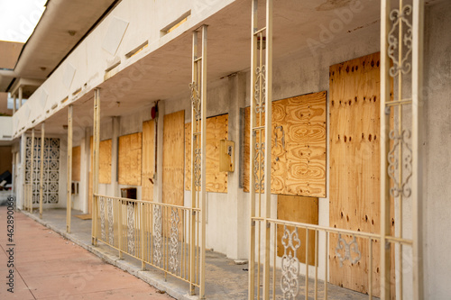 Fototapeta Condemned apartment building boarded up with plywood