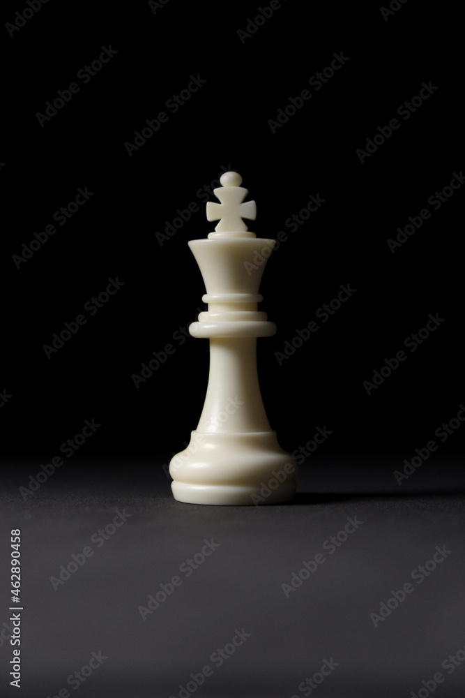 isolated white king chess piece on black background. isolated white king chess piece on black background.