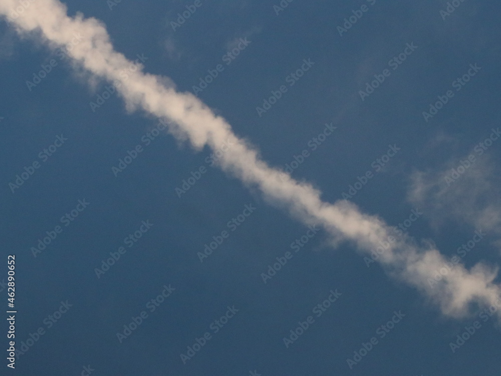 White trail from an airplane in the blue sky White trail from an airplane in the blue sky
