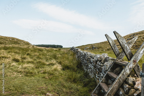 Traditional British stone wall with wooden ladder stile in countryside