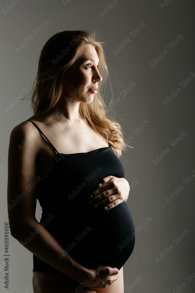 pregnant woman stroking her belly on white background. Copy space. The concept of healthy digestion, lifestyle, IVF pregnant woman stroking her belly on white background. Copy space. The concept of healthy digestion, lifestyle, IVF