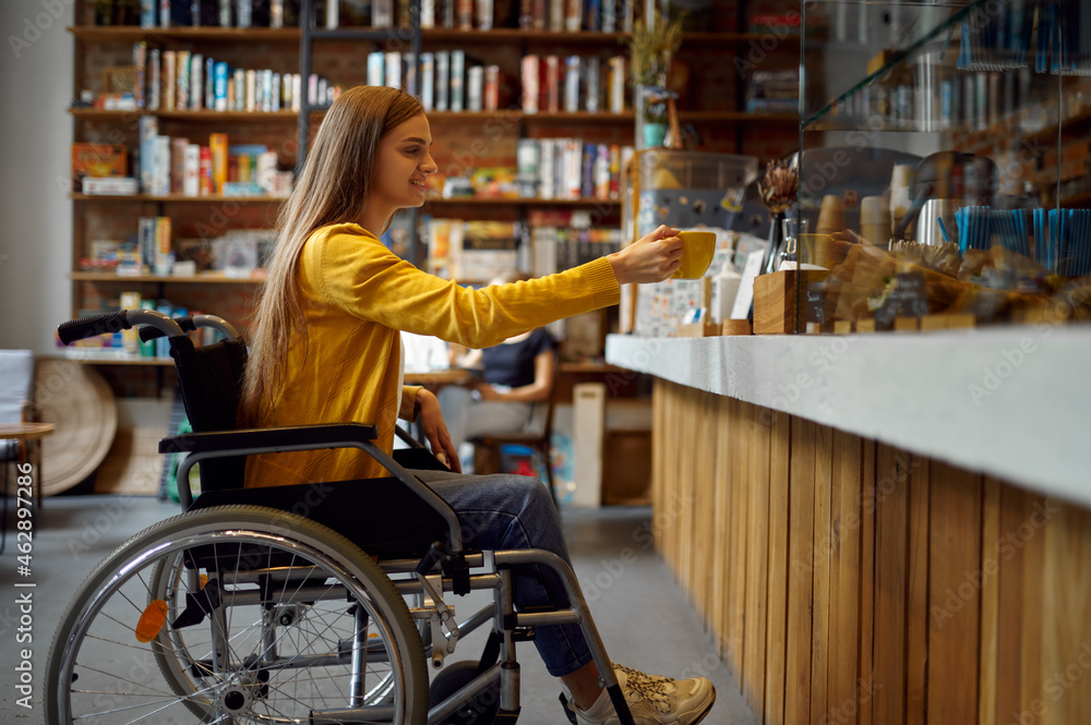 Disabled female student in wheelchair in cafe