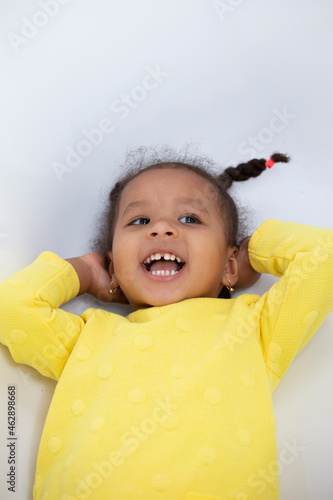 Portrait of a funny little African American girl with pigtails. photo