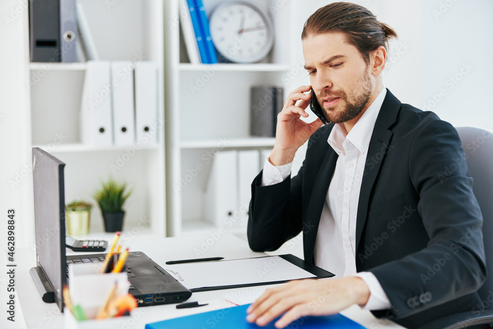 Man at the desk documents communication by phone boss Man at the desk documents communication by phone boss