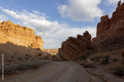The multicolored rock layers of Charyn canyon are the product of different stages of sediment deposits, which includes volcanic lava rocks at the bottom, and red debris on top. Charyn National Park.