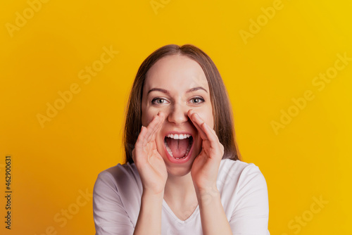 Photo of young girl hand near mouth cool advert yell tell news announcement isolated over yellow color background