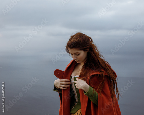 Woman in old fashioned clothes near sea photo