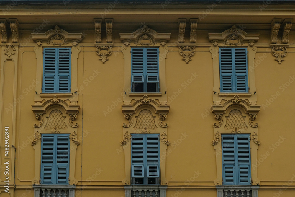 facade of the baroque yellow building with windows and blue shutters in old town. Historical architecture	