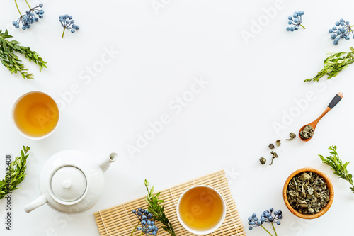 Tea drinking with white teapot and black tea in two cups