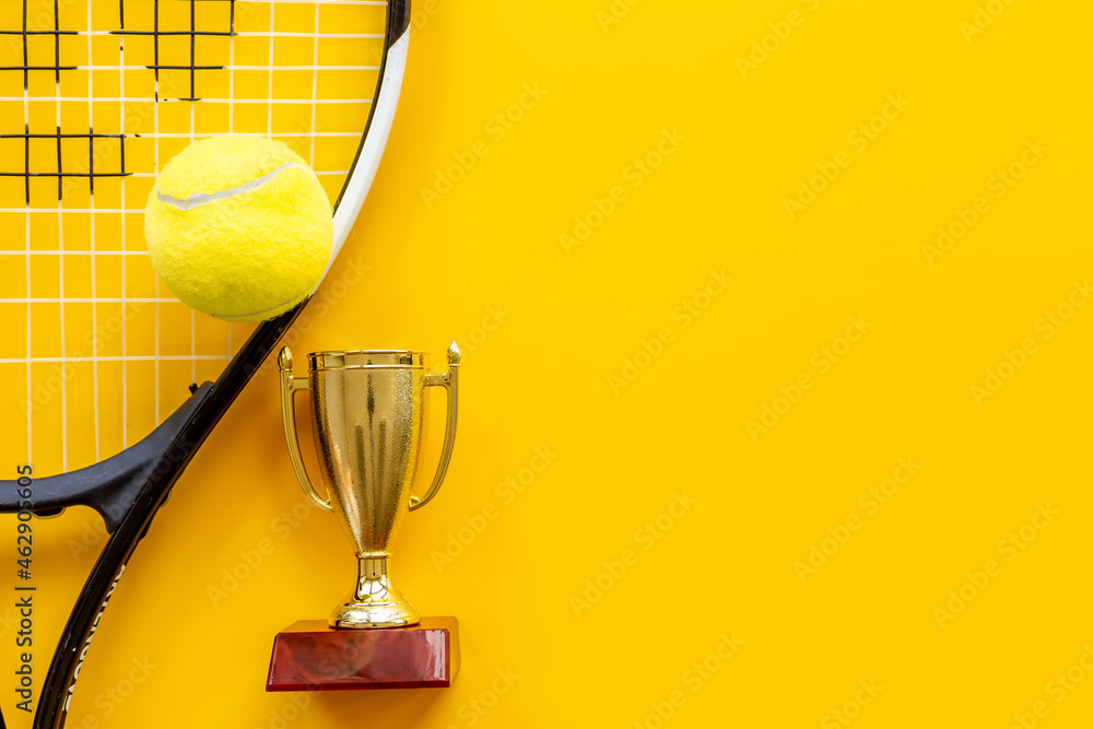 Fototapeta premium Small golden trophy cup with tennis racket and ball. Sport champion winner concept