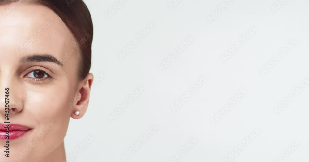 Close up portrait of beautiful caucasian female model with gathered hair and brown eyes slowly opens eyes. Half face. Close up portrait of beautiful caucasian female model with gathered hair and brown eyes slowly opens eyes. Half face.