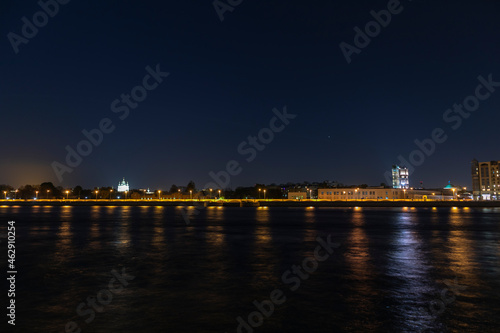 colorful night view of the city embankment across the river © Alyona_Shu