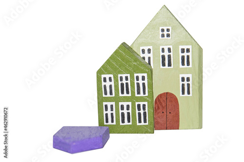 Miniature colored wooden houses isolated on a white background. Miniature wooden houses stand and one fall. High and low flat or apartment price concept. 