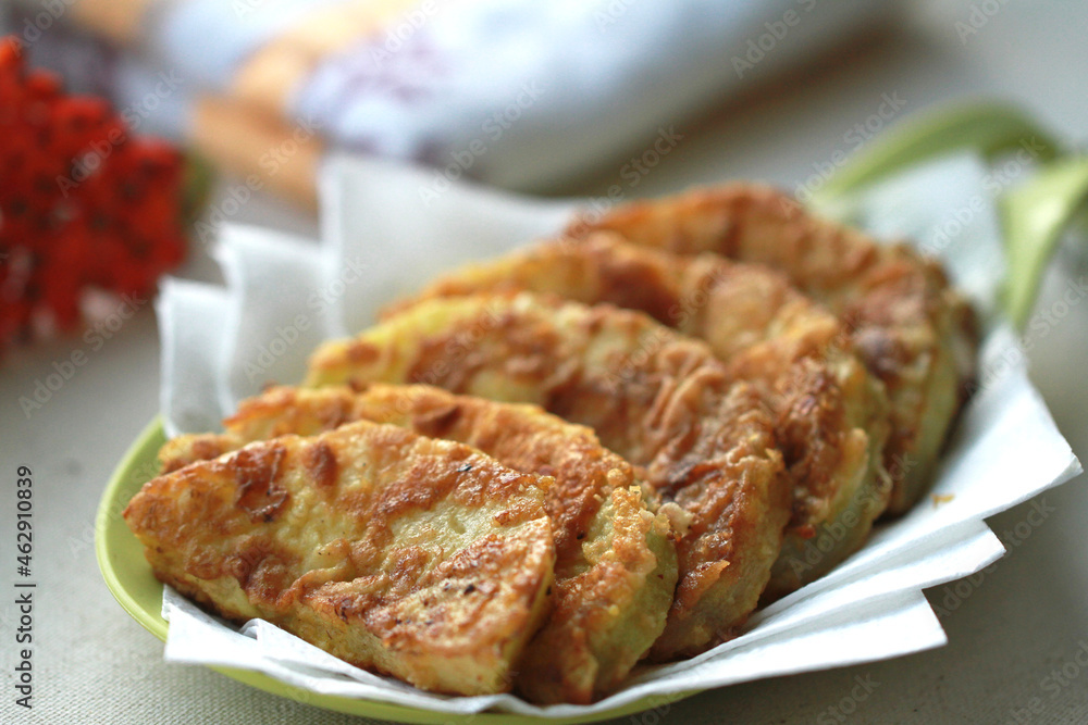 Golden slices of zucchini fried in batter. The red rowan tree symbolizes autumn. Golden slices of zucchini fried in batter. The red rowan tree symbolizes autumn.