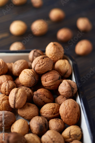 Natural whole walnuts on dark wooden table