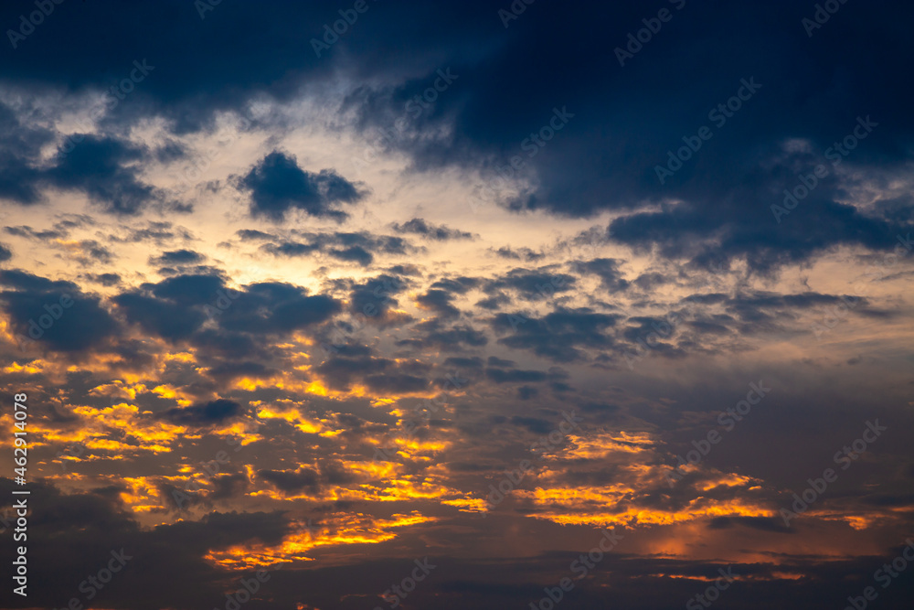 Dramatic sky with gradient lighting in warm and cool colors, black clouds and perspective to the horizon