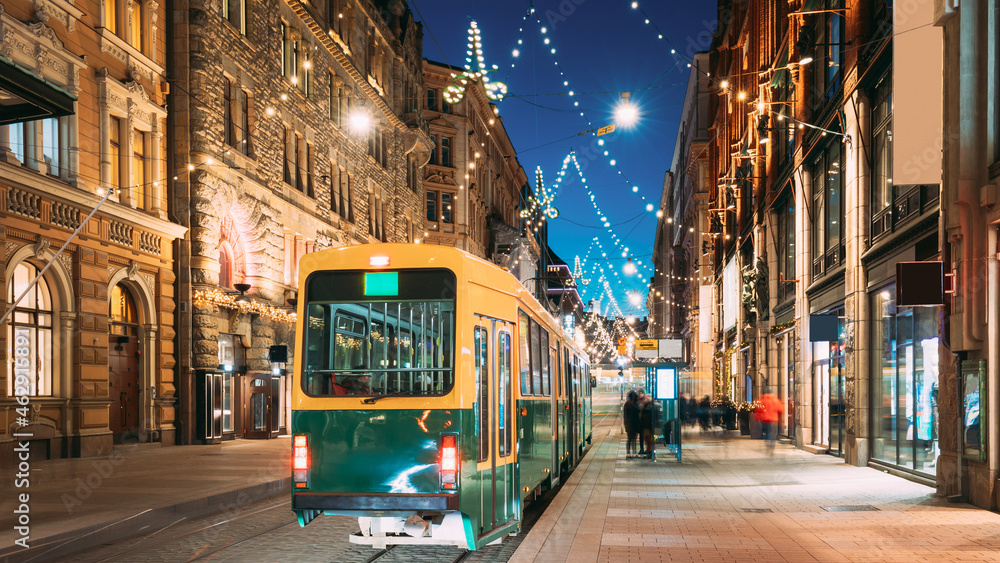 Helsinki, Finland. Tram Departs From Stop On Aleksanterinkatu Street. Night Evening Christmas Xmas New Year Festive Illumination On Street. Beautiful Street Decorations During Winter Holidays - obrazy, fototapety, plakaty 