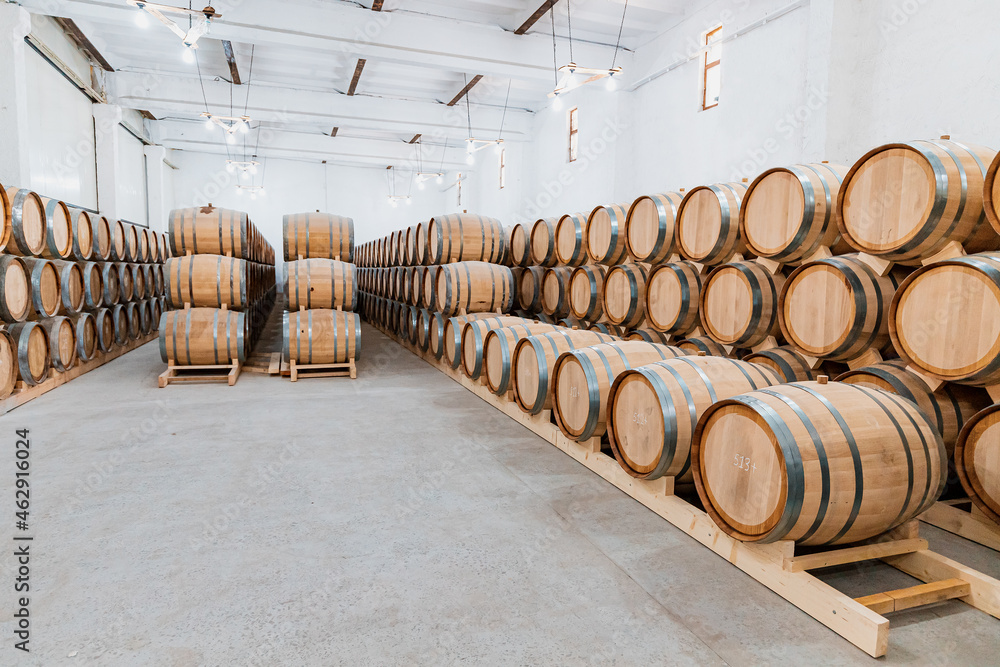 Wine wooden barrels in the cellar of the winery. Process of aging and fermentation of an alcoholic beverage. Quality and taste of product Wine wooden barrels in the cellar of the winery. Process of aging and fermentation of an alcoholic beverage. Quality and taste of product