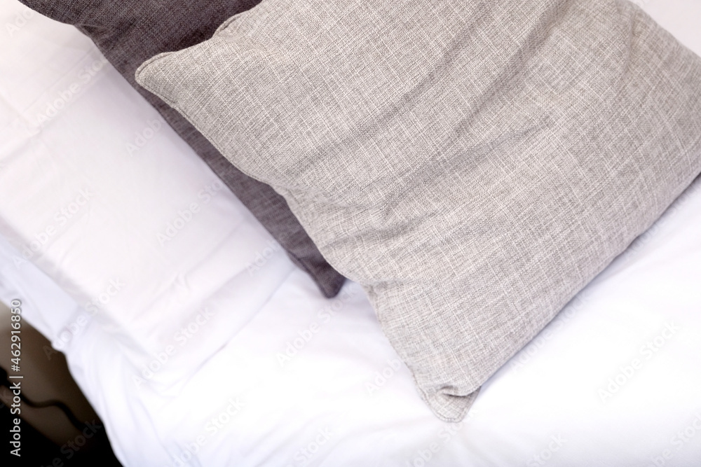close up of grey and white cushions on bed close up of grey and white cushions on bed