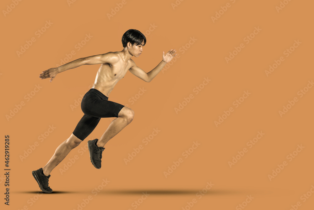 Male runner jogging Isolated. On orange background.