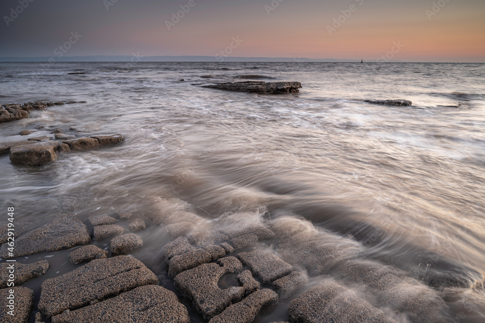 Rocky shoreline at Nash Point, Glamorgan, south Wales. Sunset over the shoreline, long exposure to smooth out the  movement in the sea. 