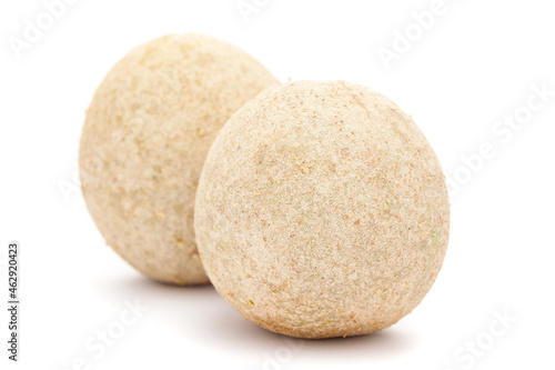 Detailed closeup of two fresh medicinal citrus  fruit of Kavath fruit   Limonia acidissima   isolated over white background