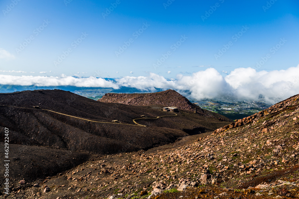 Scenic high angle view on Aso town, walk way from crater of active volcano Aso, mountains and abandoned old cable car building in Kyushu, Japan