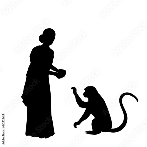 Silhouette Indian woman giving food to the monkey.