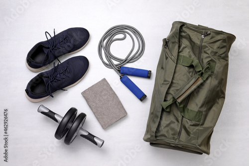 Gym bag and sports equipment on white background, flat lay