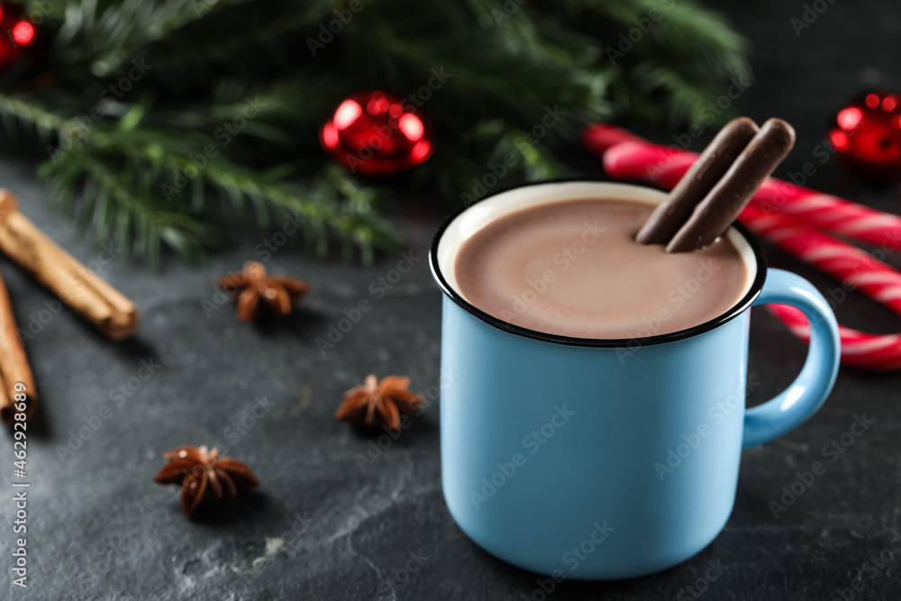 Delicious hot chocolate with cocoa sticks near Christmas decor on black table, closeup. Space for text Delicious hot chocolate with cocoa sticks near Christmas decor on black table, closeup. Space for text