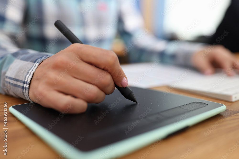Graphic editor retouching drawings on graphic tablet in studio Graphic editor retouching drawings on graphic tablet in studio