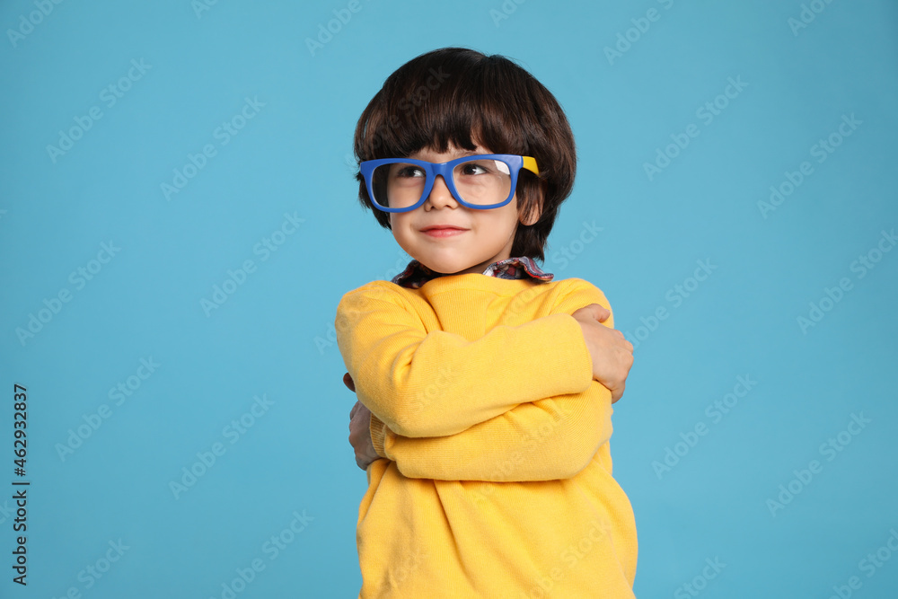 Cute little boy with funny glasses on light blue background Cute little boy with funny glasses on light blue background