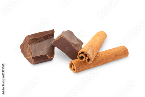 two pieces of chocolate and two cinnamon sticks on a white background