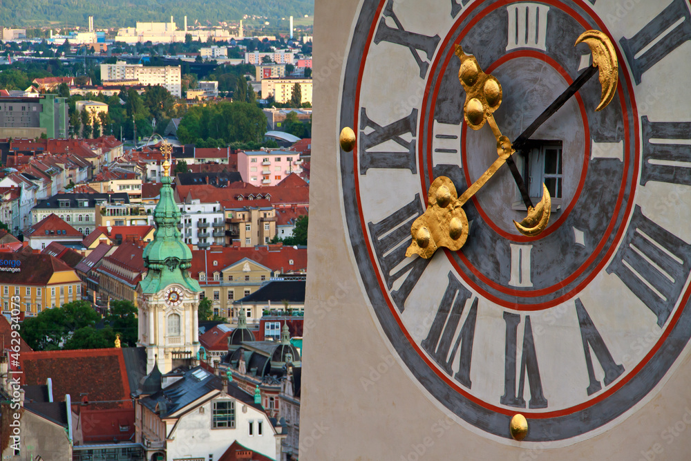 Obraz premium Landmark clocktower in Graz with huge clock and the citycentre in the back