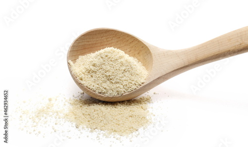 Organic sesame protein powder in wooden spoon, supplement isolated on white  