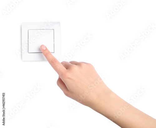 Woman pressing light switch on white background, closeup