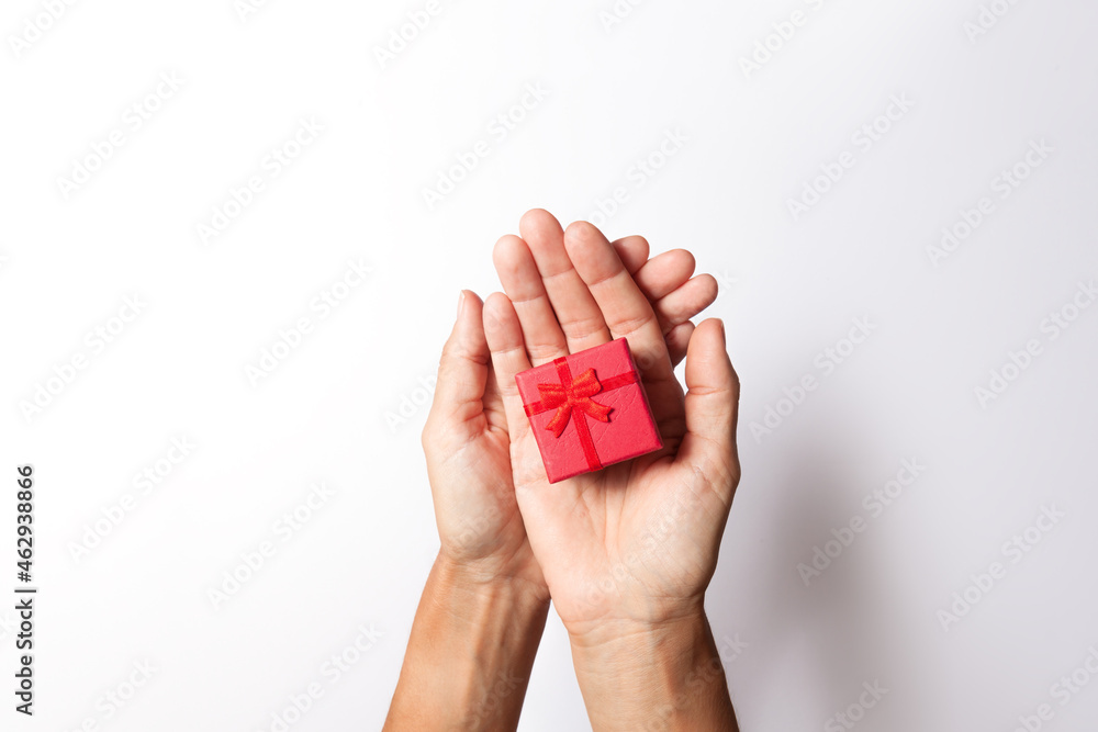woman hands handing over a red gift box on white background woman hands handing over a red gift box on white background